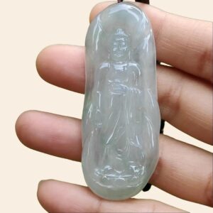 a hand holding a jade pendant
