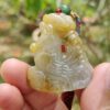 Una mano sosteniendo un colgante de jade.