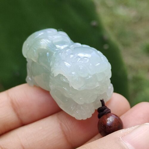 a hand holding a jade sculpture