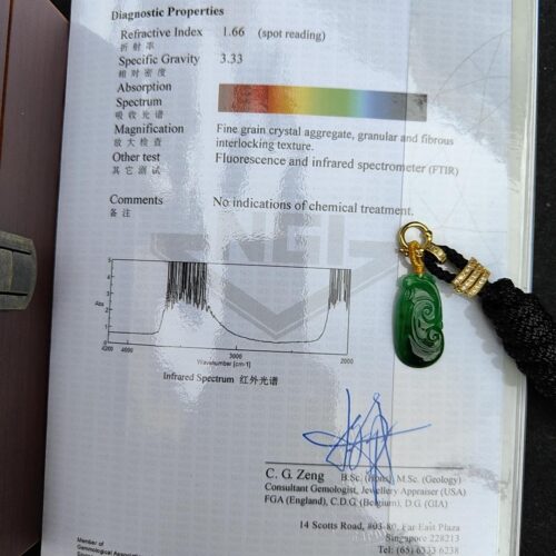 a book with a green jade pendant on it