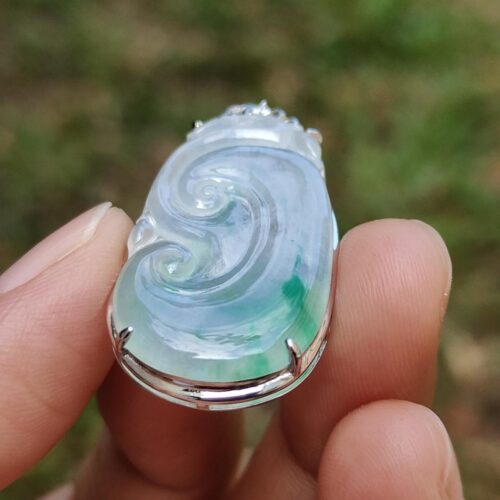 một bàn tay cầm một chiếc nhẫn ngọc bích