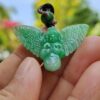 9ed5f431189d6b5b45bebf1b39e0ba3f a hand holding a green stone pendant