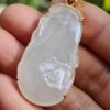 a hand holding a jade pendant