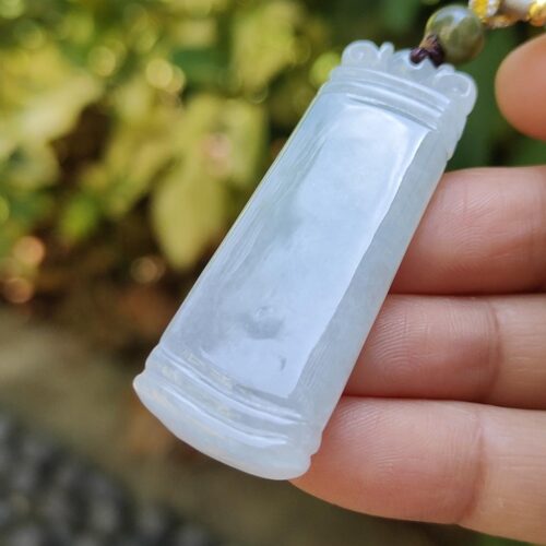 ஜேட் பதக்கத்தை வைத்திருக்கும் ஒரு கை