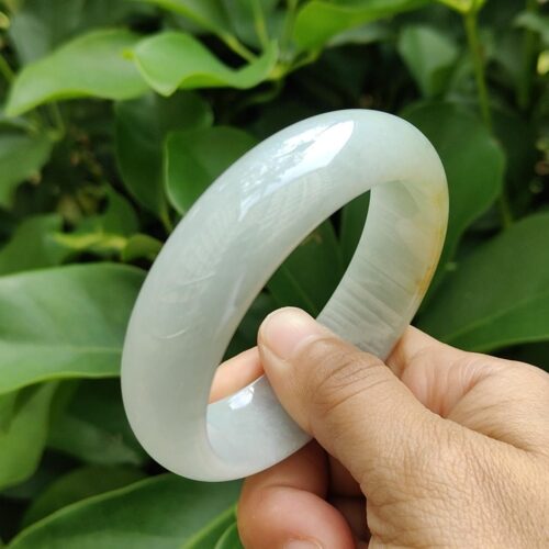 a hand holding a white bracelet