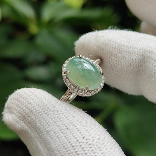 a hand wearing gloves with a ring