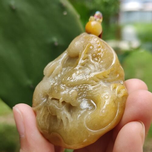 a hand holding a small yellow stone