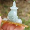a hand holding a small jade figurine
