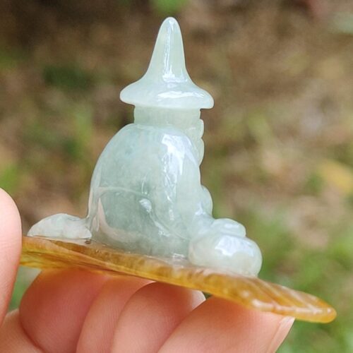 a hand holding a small jade figurine