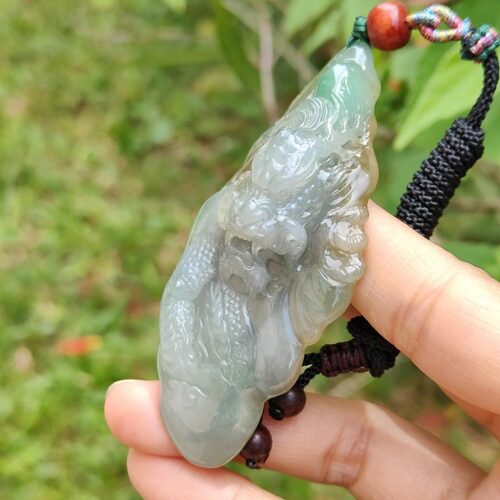 Una mano sosteniendo un colgante de jade.