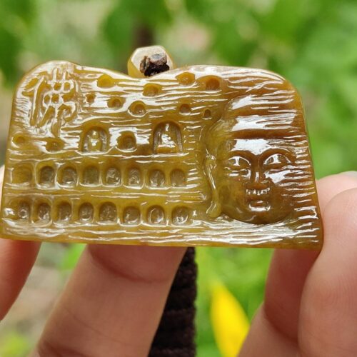 Una mano que sostiene un trozo de piedra tallada.