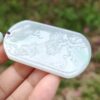 a hand holding a white pendant
