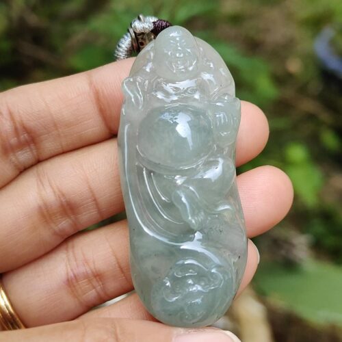 une main tenant un pendentif en jade