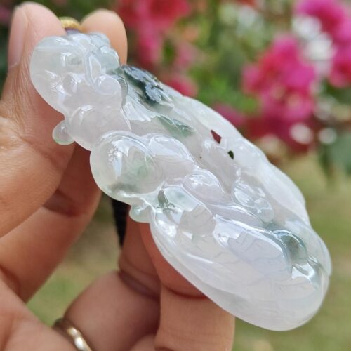 Una mano sosteniendo un colgante de jade.