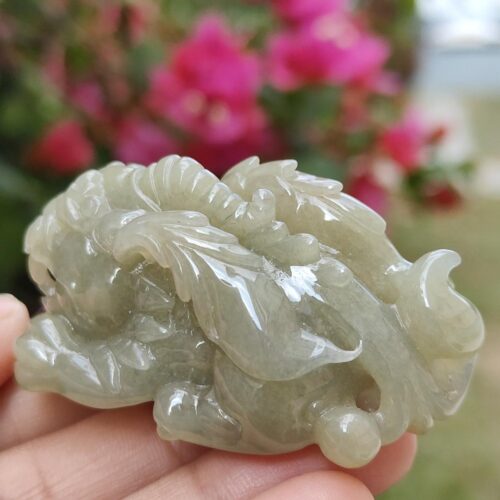 a hand holding a jade sculpture