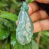 Una mano sosteniendo un colgante de jade.