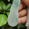 a hand holding a jade object