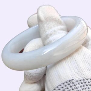 Una mano enguantada que sostiene un objeto circular blanco.