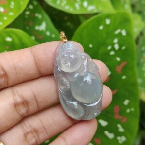a hand holding a jade pendant