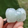 a hand holding a jade animal