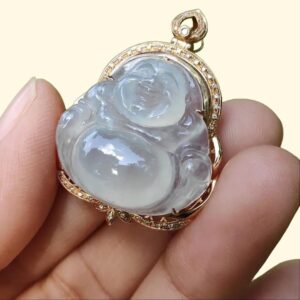 a hand holding a jade pendant