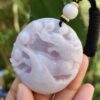 Una mano sosteniendo un colgante de jade.