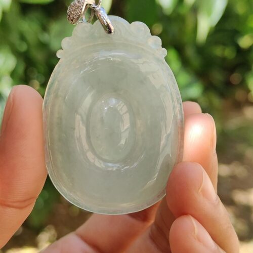 翡翠のペンダントを持つ手