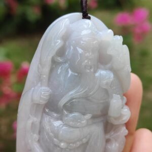 Una mano sosteniendo un colgante de jade.