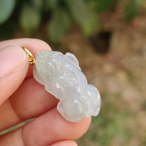 Una mano sosteniendo un colgante de jade.