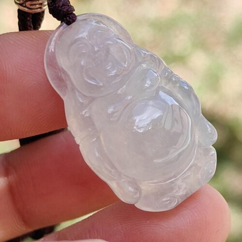 a hand holding a jade pendant
