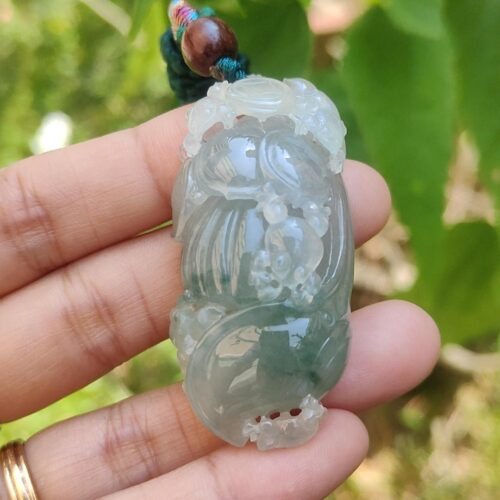 翡翠のペンダントを持つ手