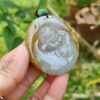 a hand holding a jade pendant