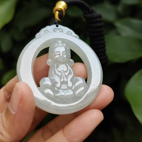 a hand holding a jade pendant