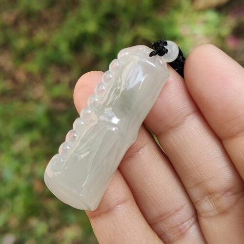 Una mano sosteniendo un colgante de jade.