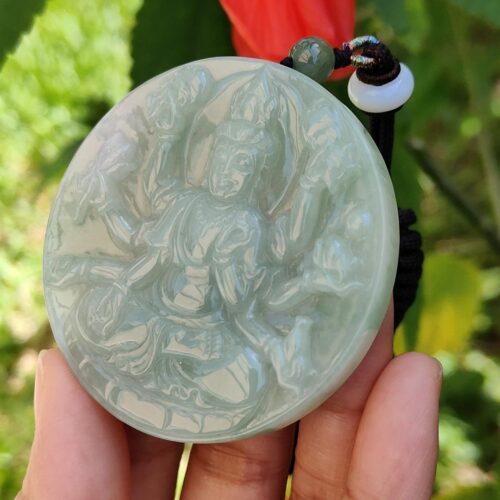 Una mano sosteniendo un medallón de jade.