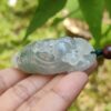 翡翠のペンダントを持つ手