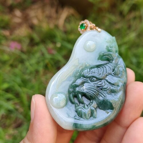 une main tenant un pendentif en jade