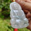 a hand holding a jade pendant