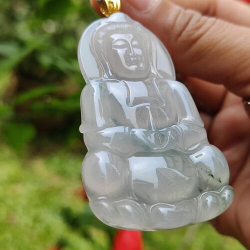 a hand holding a jade pendant