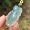 a hand holding a jade pendant