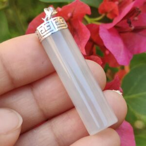 하얀색 수정 펜던트를 쥔 손