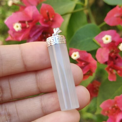 a hand holding a crystal pendant