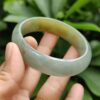 a hand holding a jade ring