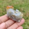 Una mano sosteniendo un pequeño animal de piedra.