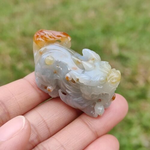 Una mano sosteniendo un pequeño animal de piedra.
