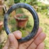 a hand holding a round stone ring
