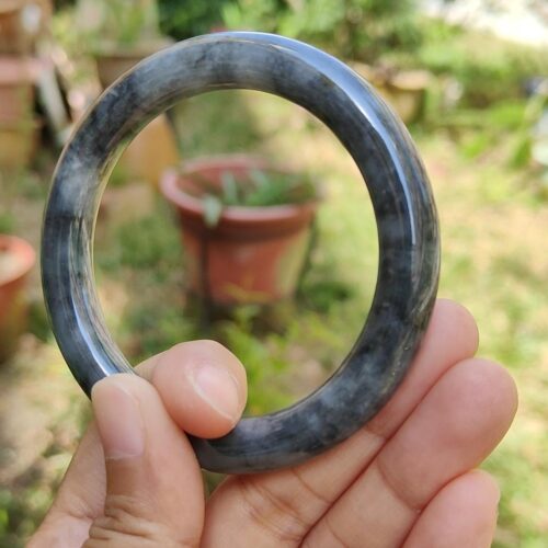 a hand holding a round stone ring