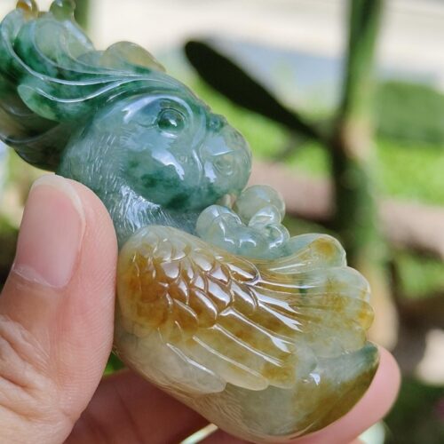 a hand holding a jade bird