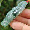 a hand holding a jade pendant