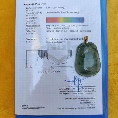 a green jade pendant on a piece of paper